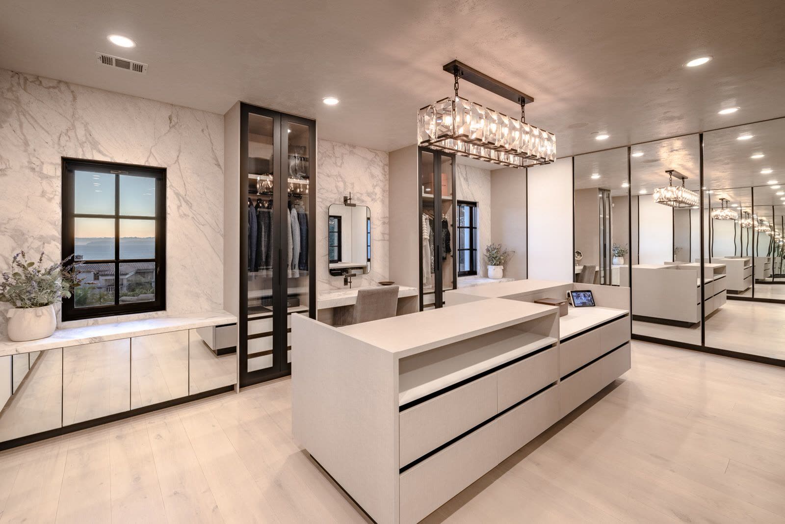 Fitted dressing room with a central island and mirrored cabinetry