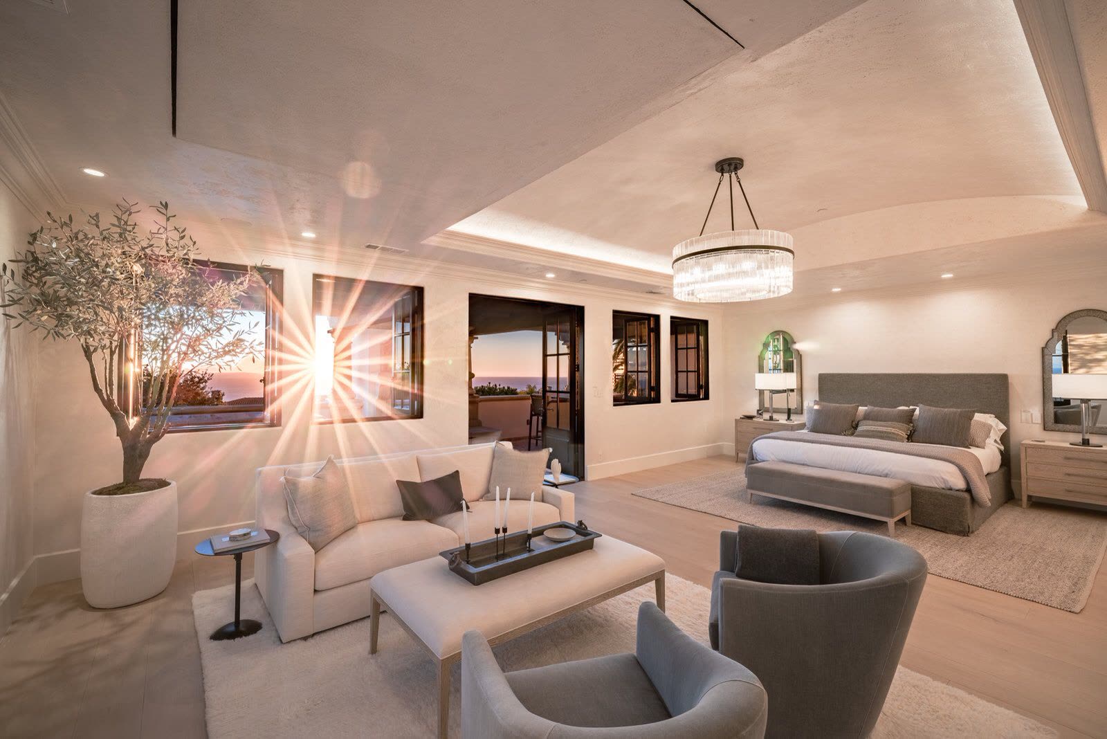 Primary bedroom suite opening to a terrace, with low-slung seating and an olive tree